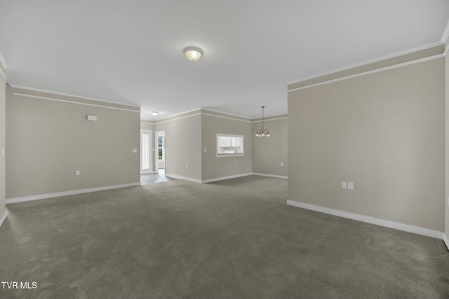 spare room featuring dark colored carpet, crown molding, and a notable chandelier