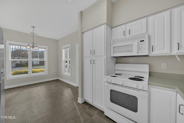 kitchen featuring white cabinets, pendant lighting, white appliances, and a chandelier