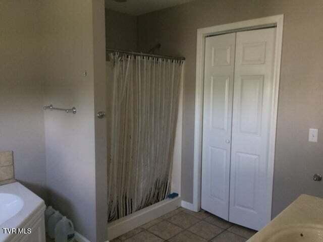 bathroom featuring tile patterned floors, vanity, and a shower with shower curtain