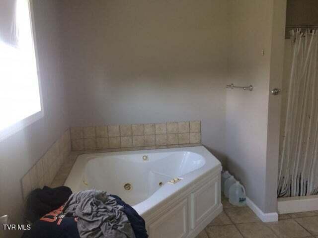 bathroom with tile patterned flooring and a bathing tub