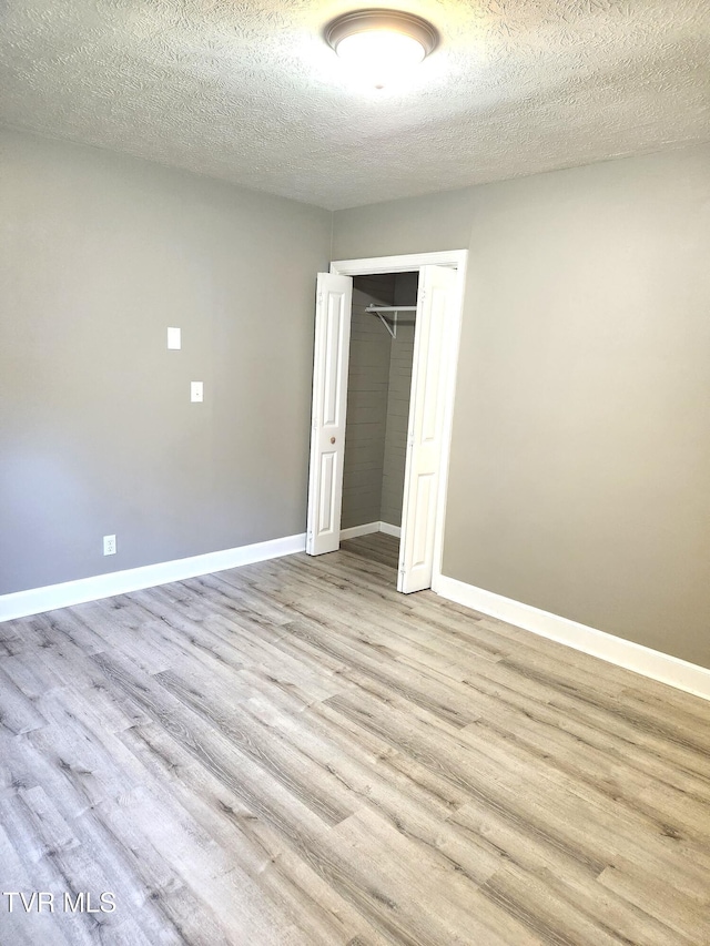 empty room featuring light hardwood / wood-style flooring and a textured ceiling