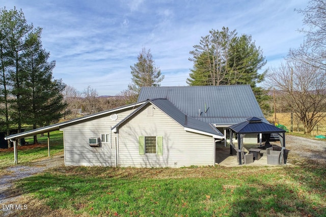 view of side of home with a gazebo, a carport, and a yard