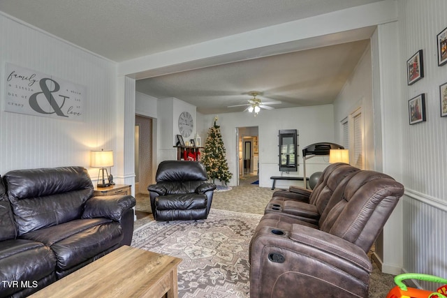 carpeted living room featuring ceiling fan and a textured ceiling