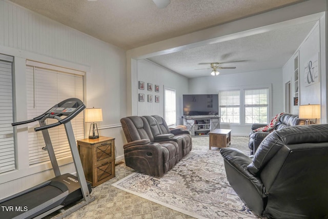 carpeted living room with a textured ceiling and ceiling fan