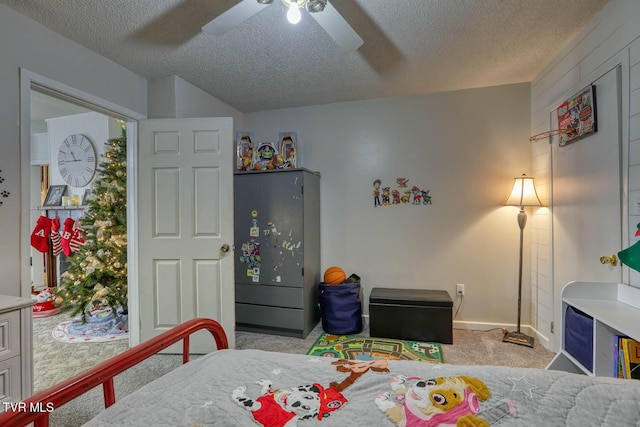 bedroom with ceiling fan, light carpet, and a textured ceiling