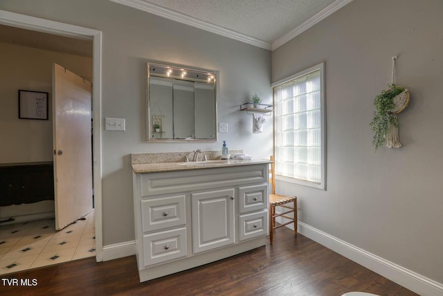 bathroom featuring crown molding, vanity, wood-type flooring, and a textured ceiling