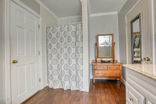 bathroom featuring curtained shower, wood-type flooring, a textured ceiling, vanity, and ornamental molding