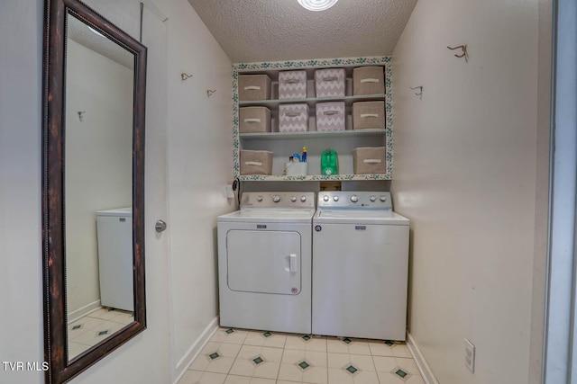 clothes washing area featuring washer and dryer and a textured ceiling