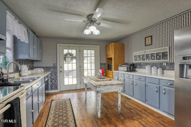 kitchen with appliances with stainless steel finishes, dark hardwood / wood-style flooring, ceiling fan, crown molding, and sink