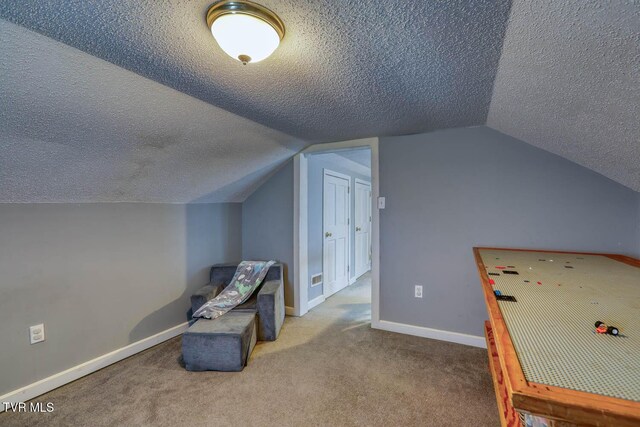 rec room with lofted ceiling, carpet floors, and a textured ceiling