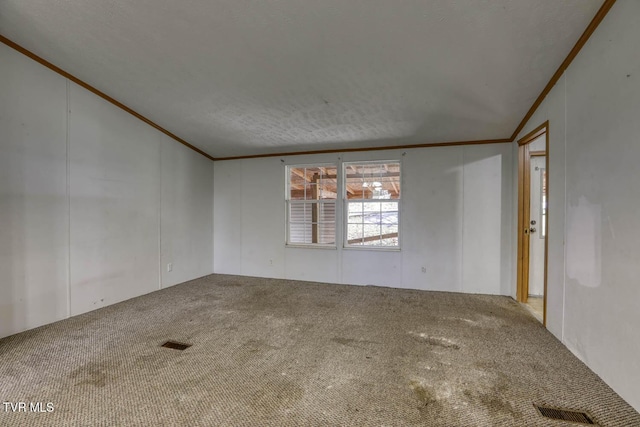 unfurnished room featuring a textured ceiling, carpet floors, lofted ceiling, and ornamental molding