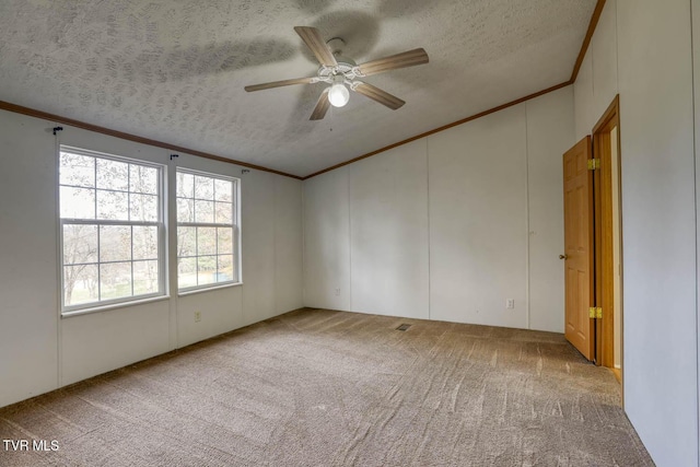 spare room featuring carpet flooring, ceiling fan, a textured ceiling, and ornamental molding