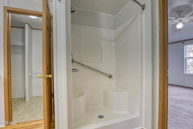 bathroom featuring a shower, a textured ceiling, hardwood / wood-style flooring, and ceiling fan