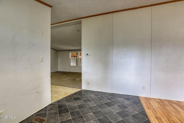 carpeted spare room featuring crown molding and a textured ceiling