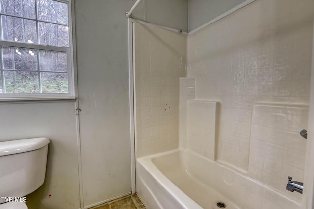 bathroom featuring bathing tub / shower combination, a wealth of natural light, and toilet