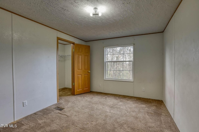 unfurnished bedroom with light carpet and a textured ceiling