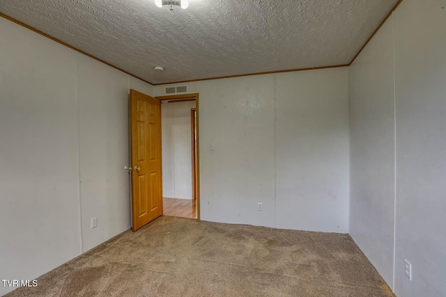 spare room with a textured ceiling and light carpet