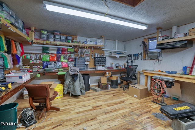 miscellaneous room featuring a workshop area and wood-type flooring