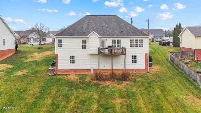 back of house with a yard and a balcony