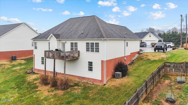 rear view of house with a lawn, central AC unit, and a balcony