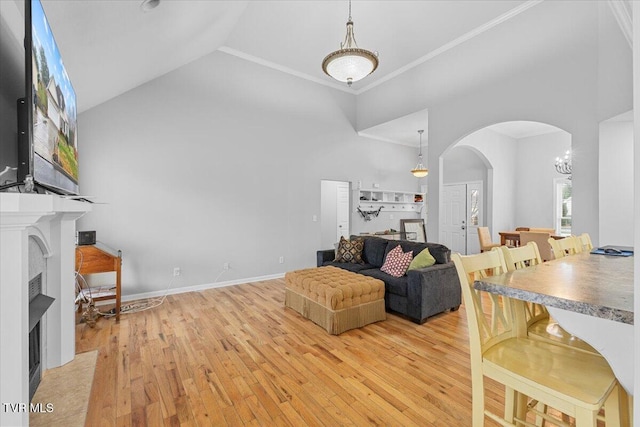 living room with high vaulted ceiling and light wood-type flooring