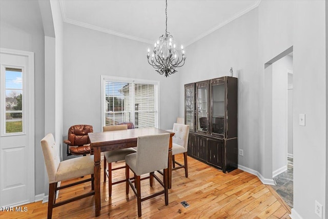 dining area with light wood-type flooring, plenty of natural light, and ornamental molding