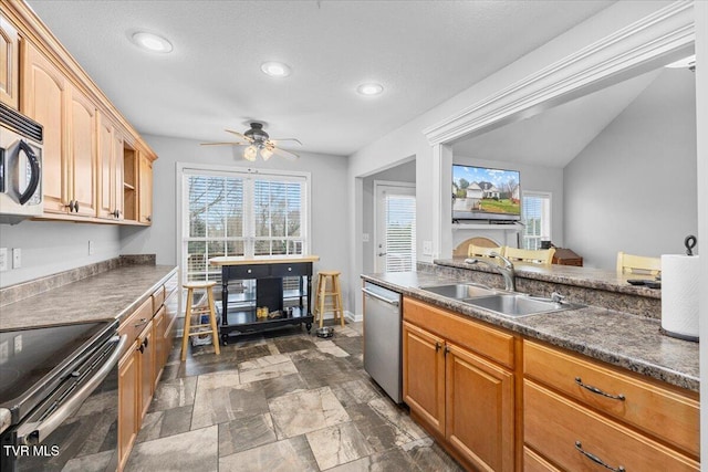 kitchen featuring ceiling fan, sink, stainless steel appliances, and lofted ceiling