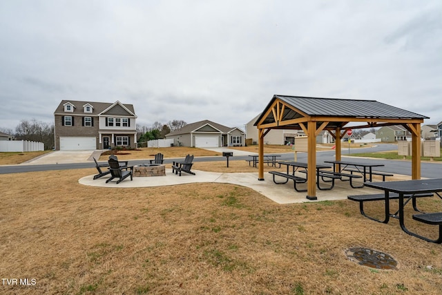 view of property's community with a gazebo, a yard, and a fire pit