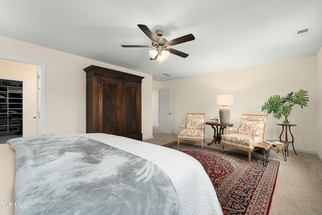 bedroom with a spacious closet, a closet, carpet floors, and ceiling fan