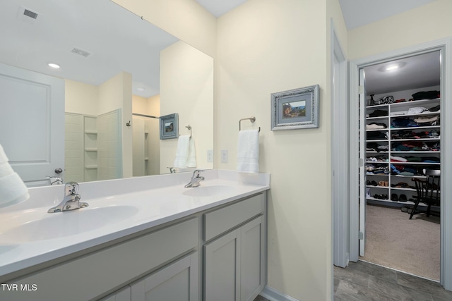 bathroom featuring walk in shower and vanity