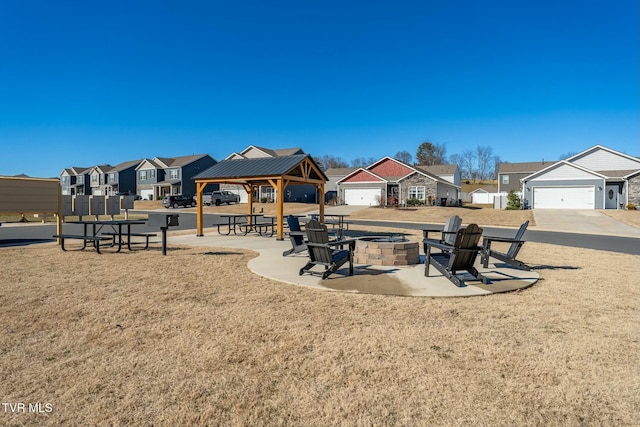 view of playground featuring a lawn, a gazebo, and a fire pit