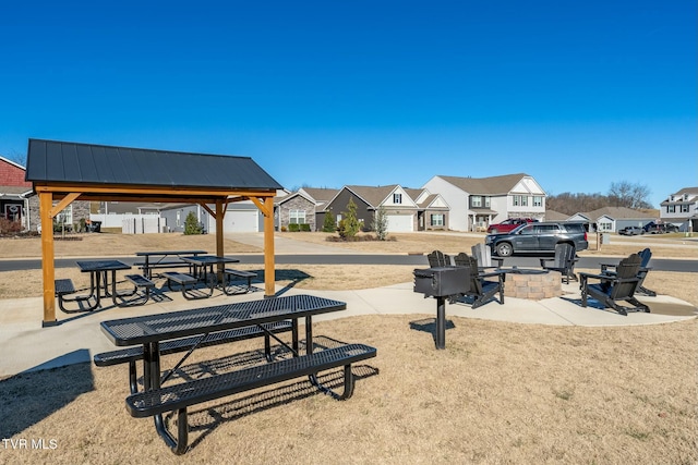 view of community featuring an outdoor fire pit, a gazebo, and a patio