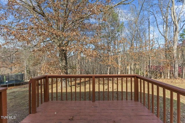 deck featuring a lawn and a trampoline