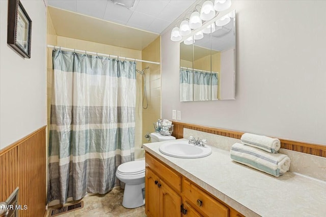 full bathroom with wood walls, vanity, shower / bath combination with curtain, and toilet