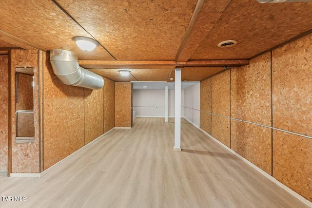 basement with light hardwood / wood-style flooring