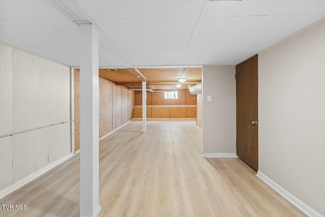 basement with wood walls and wood-type flooring