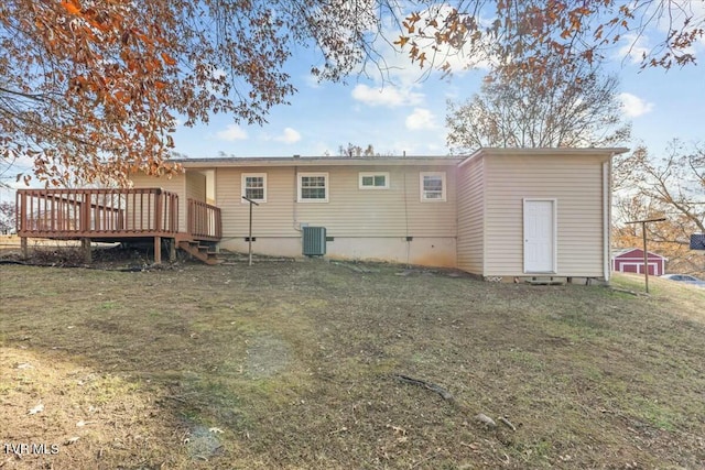 rear view of property featuring central air condition unit, a yard, and a deck