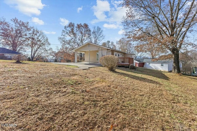 view of front of property featuring a front yard, a carport, and a wooden deck