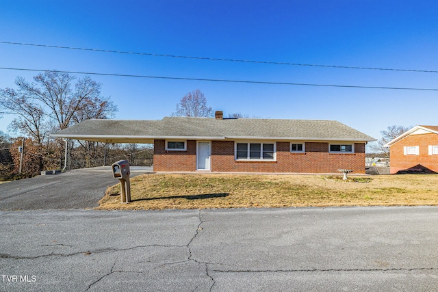 ranch-style house with a front lawn and a carport