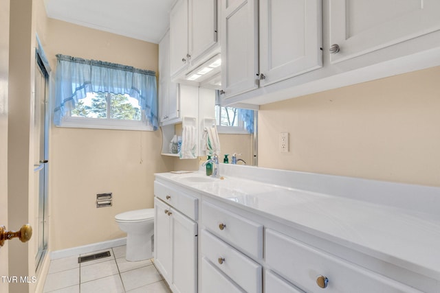 bathroom with tile patterned flooring, vanity, a shower with door, and toilet