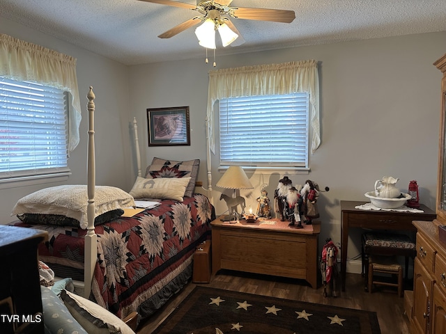 bedroom featuring a textured ceiling, dark hardwood / wood-style floors, and ceiling fan