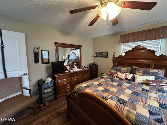 carpeted bedroom featuring a textured ceiling and ceiling fan