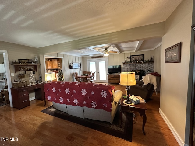 living room featuring beam ceiling, ceiling fan, french doors, and hardwood / wood-style flooring