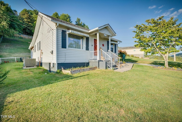 view of front of house featuring central AC unit and a front lawn