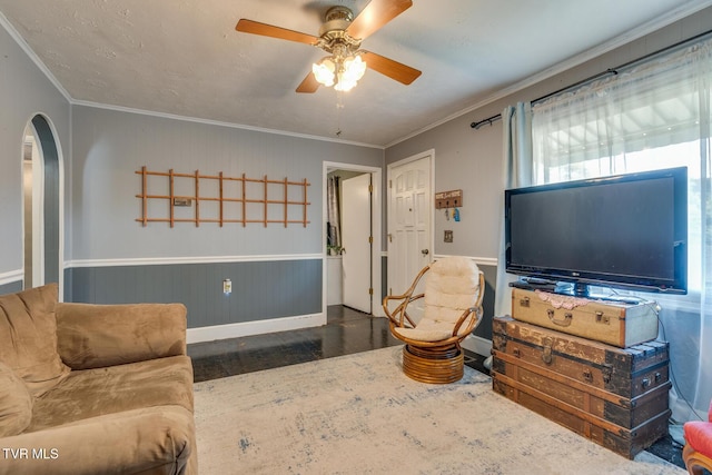 living room featuring dark hardwood / wood-style flooring, ceiling fan, and ornamental molding