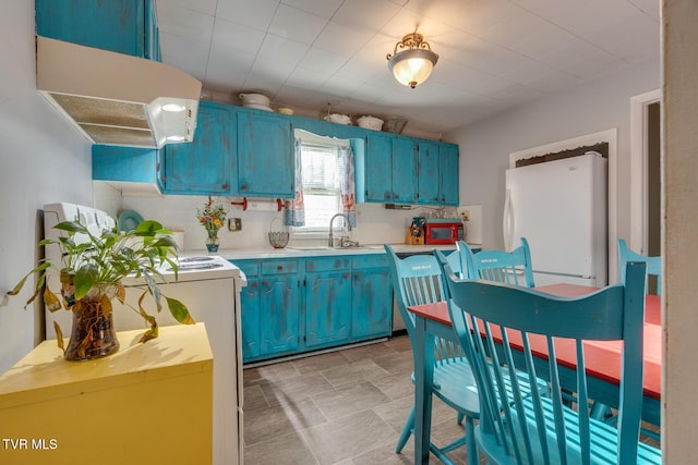 kitchen featuring blue cabinets, sink, exhaust hood, white refrigerator, and range