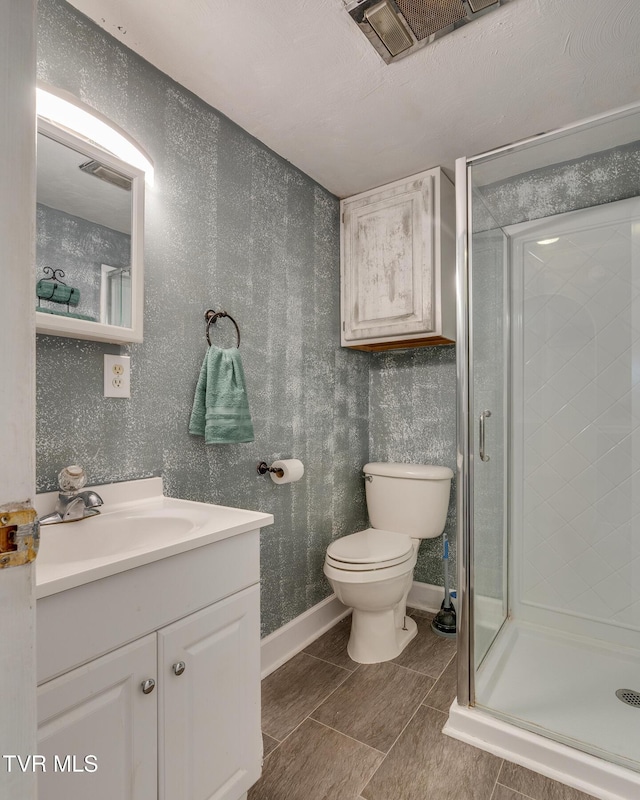 bathroom with tile patterned floors, vanity, toilet, and an enclosed shower