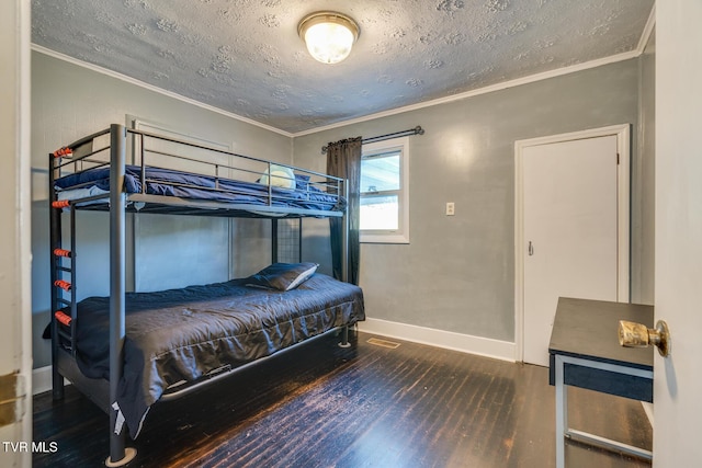 bedroom featuring hardwood / wood-style flooring, crown molding, and a textured ceiling