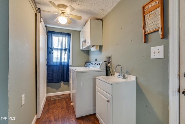 laundry area with cabinets, ceiling fan, a textured ceiling, dark hardwood / wood-style flooring, and washing machine and clothes dryer