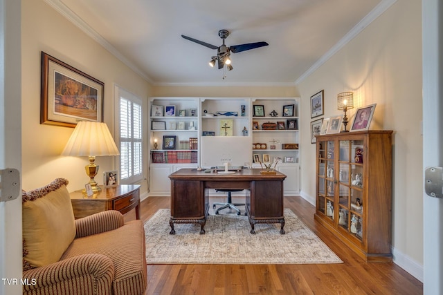 home office featuring ceiling fan, wood-type flooring, and ornamental molding